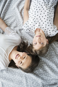 Two teenage girls relaxing in bedroom