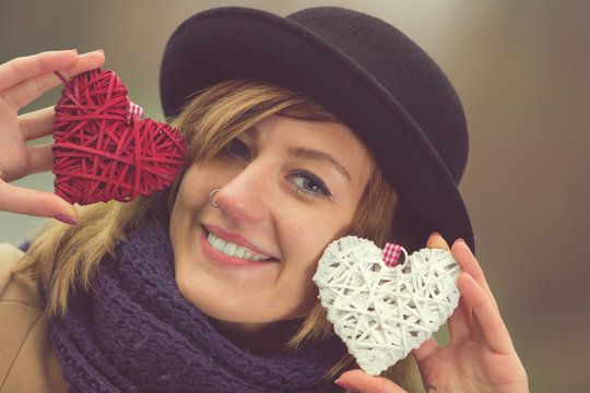 Young hipster woman holding hearts.
