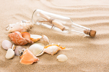 Message in bottle on the beach. Summer background with hot sand