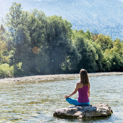 Woman meditating at the river