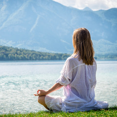Fototapeta na wymiar Woman meditating at the lake