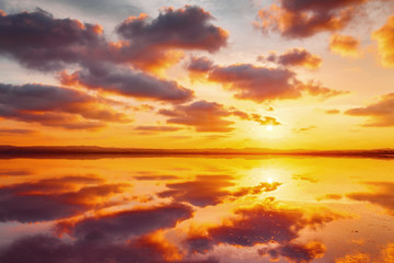 Fototapeta na wymiar Beautiful cloudy sky above salt water lake. Scenic sunset landscape.