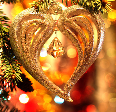 Christmas heart decoration on holiday background with bell and pine tree twigs