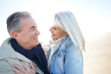 Portrait of senior couple having fun at the beach, wintertime