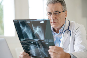 Portrait of senior doctor examining X-ray