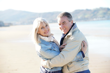 Portrait of senior couple having fun at the beach, wintertime