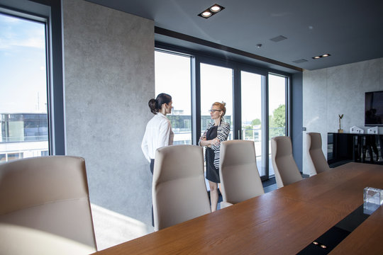 Two businesswomen talking in board room