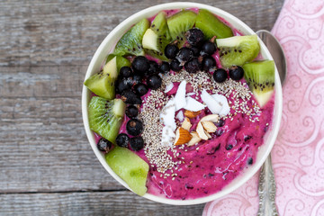 Smoothie bowl with kiwi, chia, coconut and berries. Love for a healthy raw food concept.