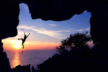 Rock climbing in the cave on the mountain at sunset. 
