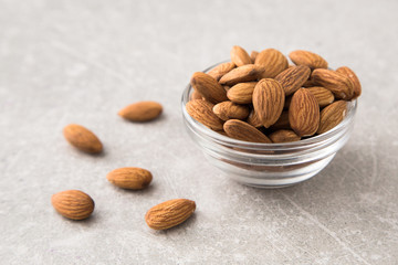 Almond in the glass bowl on stone table.