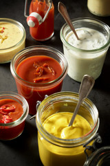 Mustard, ketchup, mayonnaise as dips in jars