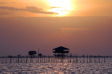 The fishermen cottage and oyster farms along the coast with sunrise background 
