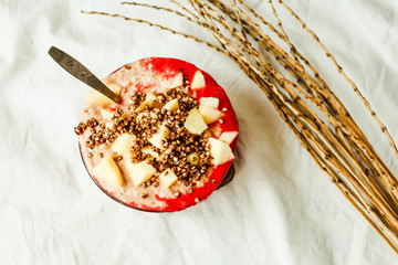smoothie bowl with banana, apple and strawberry sauce, top view
