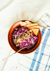 raw bright red cabbage salad with seeds and.corn crackers, top v