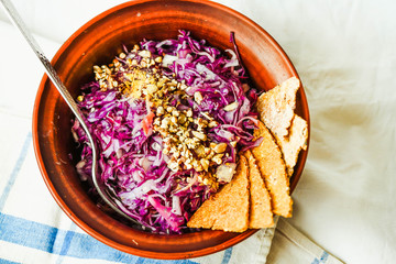 raw red cabbage salad with seeds and.corn crackers, top view