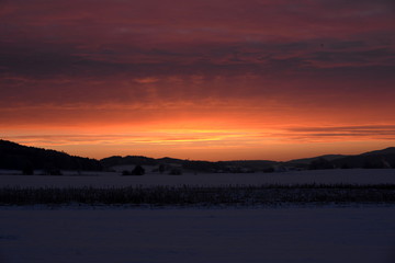Fototapeta na wymiar der Himmel brennt bei minus 20 Grad, herrlicher Sonnenaufgang in eisiger Winterlandschaft