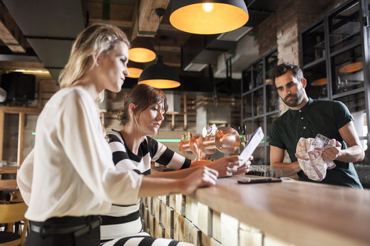 Two women looking at menu card on coffee shop