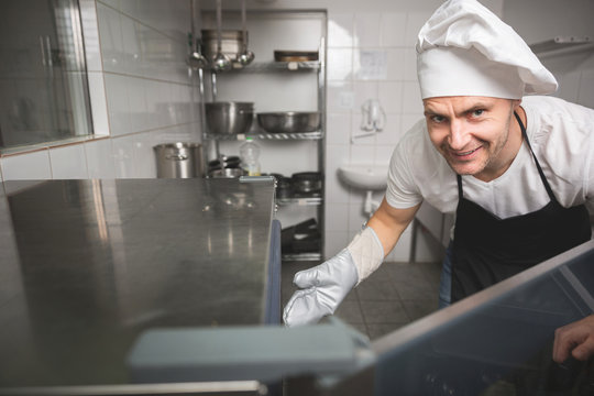 Smiling chef opening oven