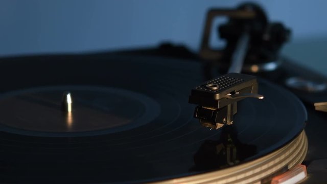 Record player playing an old fashioned vintage vinal record. The needle is being put on the record.
