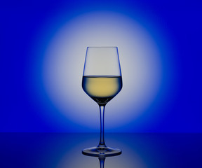 Wineglass with white wine on blurred  background