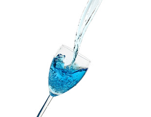 Creative splashing of blue water in the glass