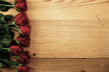Red roses on the textured wood with copy space