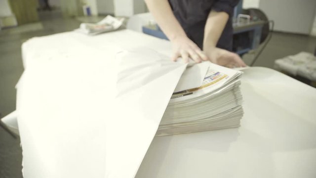 pile of finished newspapers is wrapped in printing plant.