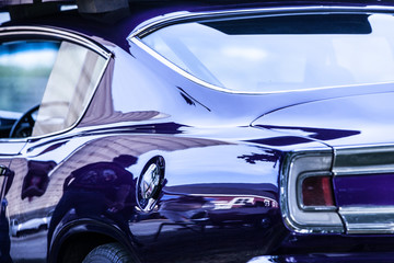 Obraz na płótnie Canvas A shiny purple car show car reflecting a barn.