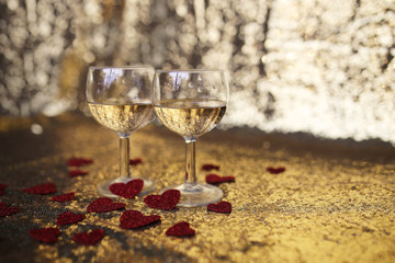 Two Sparkling White Wine in Glasses with Heart Confetti and Gold