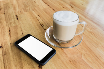 cup of coffee and smart phone on wooden table