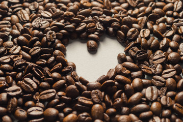 Coffebeans on Neutral Gray Background. Dark Roast Coffee. Heart.
