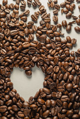 Coffebeans on Neutral Gray Background. Dark Roast Coffee. Heart.