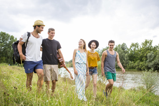 Group of friends taking a walk on the riverbank