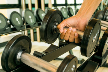 Fototapeta na wymiar a man is exercise in the gym with dumbbell