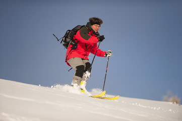 Fototapeta na wymiar Alpine skier. Mid adult man skiing down steep hill in nature.