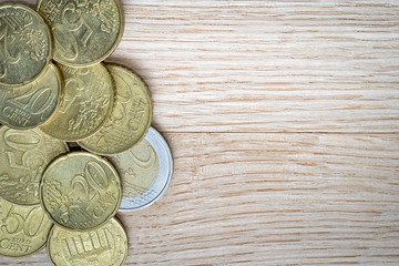 Pile of euro coins on the wooden background, copy space
