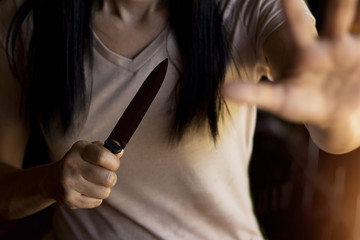  Woman holding a knife in hand while defending herself from attack