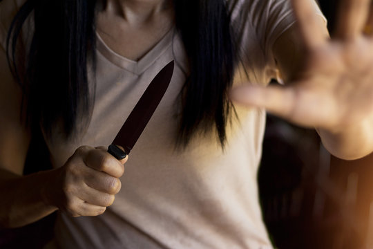  Woman Holding A Knife In Hand While Defending Herself From Attack