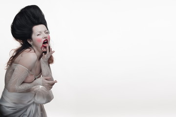 emotional brunette actress in the role of a vampire with blood drops on his face. 
woman in a...