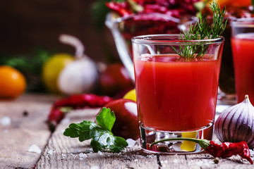 Spicy tomato juice with salt and spices, vintage wooden backgrou