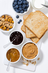 peanut butter, jams and toasts for breakfast, vertical top view