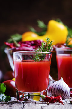Spicy tomato juice with salt and spices, vintage wooden backgrou