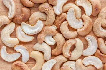 Roasted cashew nuts texture on wooden background.