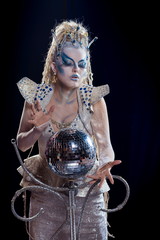 emotional actress woman in makeup and costume of the Snow Queen in the blue-black background