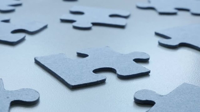 Slow tilt over problem solving toys arranged chaotically DOF 4K 2160p 30fps UHD tilting footage - Jigsaw puzzle blue pieces on the table shallow 3840X2160 UltraHD video 