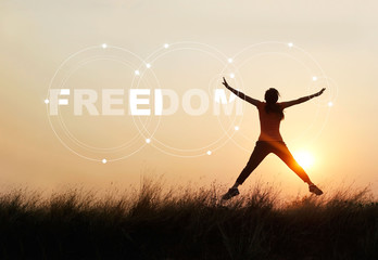 Fototapeta na wymiar Woman jumping against sunset with word freedom, enjoyment concept