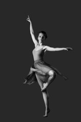 girl dancing barefoot. ballet. grey background
