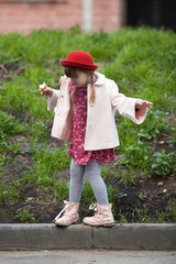 kid girl with pigtails in hat  eating ice cream and walks