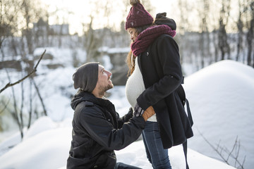 Pregnant couple have fun in winter nature