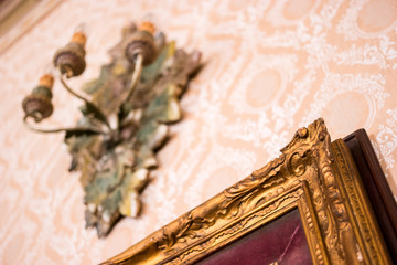 Corner of old gilded frame. Frame with ornament on wall. Art of the past.